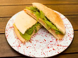 Sándwich de mortadella con pistachos, rúcula y queso dambo