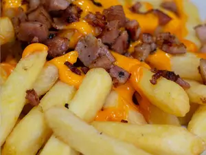 Porción de papas fritas con cheddar y bacon