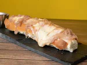 Hot dog con queso muzzarella y cebolla caramelizada