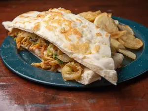 Sándwich de muslito de pollo salteado con verduras al vapor