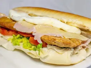 Sandwich de milanesa de carne con jamón y queso con guarnición a elección