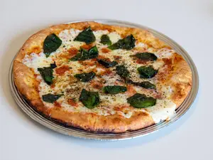 Pizza muzzarella con albahaca