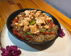 Wok de fideos de arroz con salmón rosado