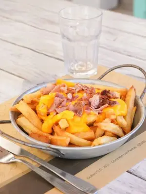 Papas fritas con cheddar y panceta