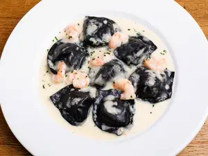 Raviolones negros de salmón