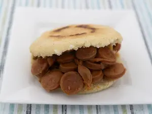 Arepa asada con salchichas guisadas