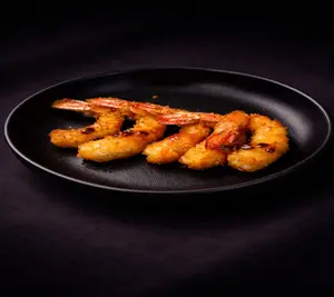 Langostinos rebozados, bañados con salsa de miel y maracuyá (5 unidades)