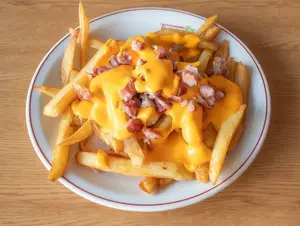 Porción de papas fritas con cheddar y panceta