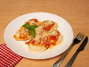Sorrentinos con salsa y queso
