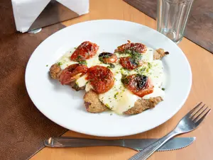 Milanesa con tomates asados