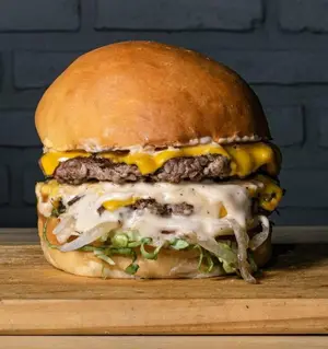 Tasty burger doble con papas.