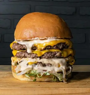 Tasty burger triple con papas.