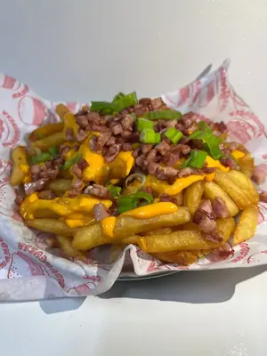 Papas fritas con cheddar, bacon y verdeo